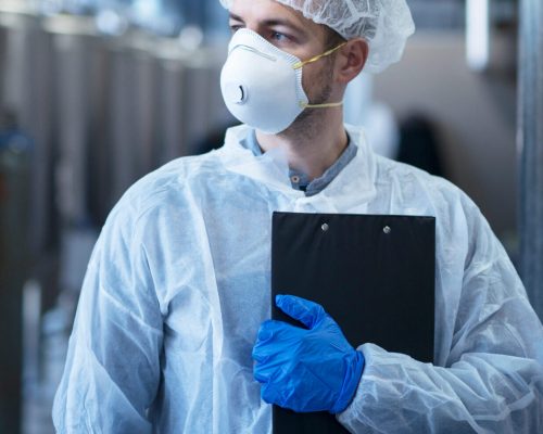 Technologist,In,Protective,White,Suit,With,Hairnet,And,Mask,Standing